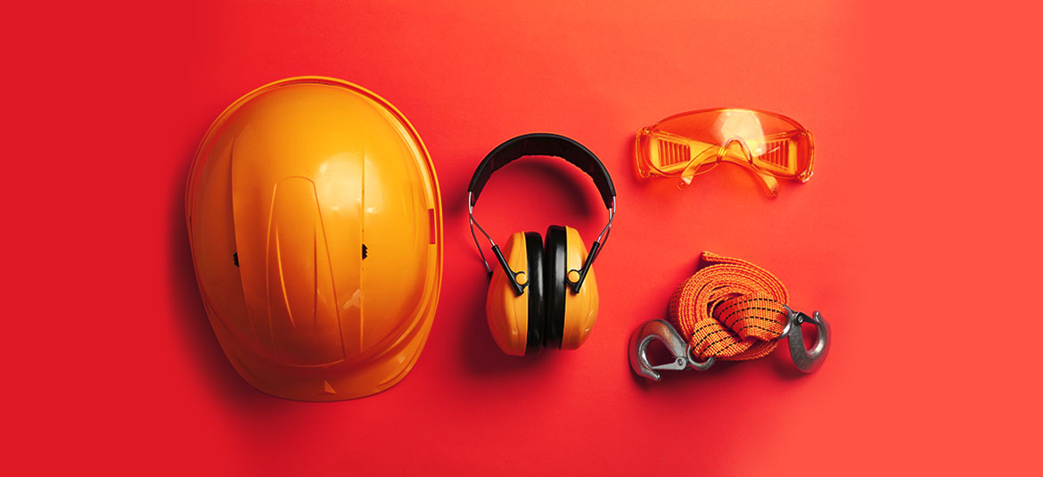 Ausrüstung Arbeitsschutz auf orangem Hintergrund