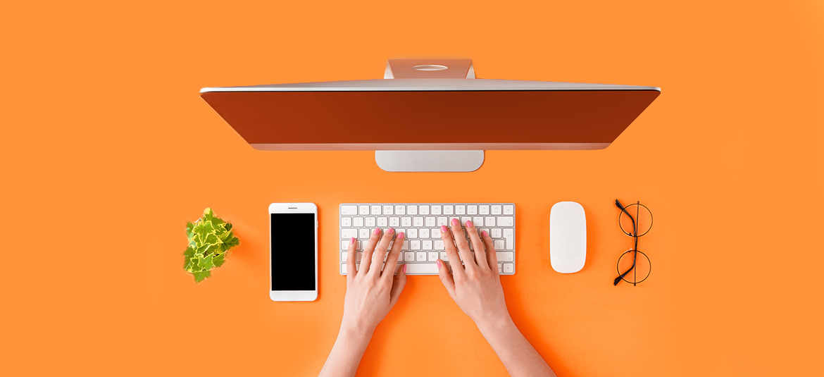 Computer, Handy und Tastatur auf orangem Hintergrund